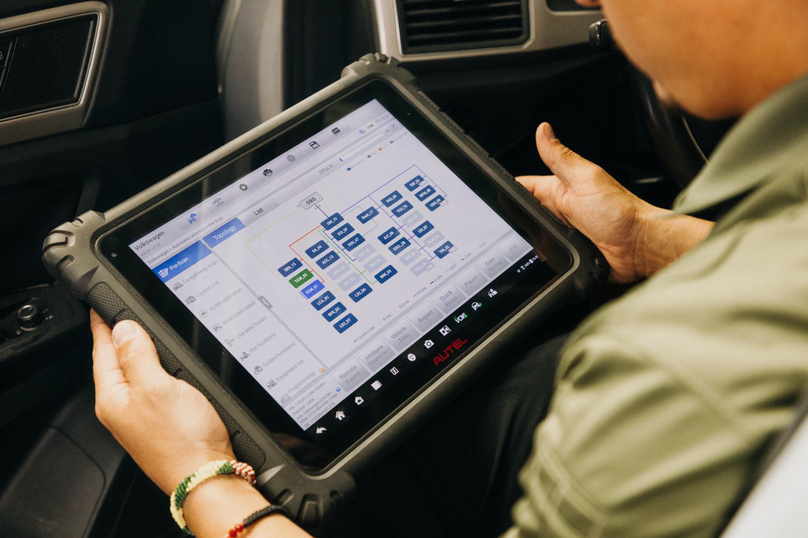 Technician reviewing a vehicle network scan on a diagnostic tablet