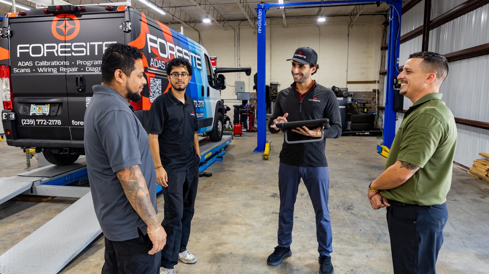The Everglades Auto Care team talking in the shop next to the mobile service van
